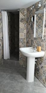 a bathroom with a white sink and a shower at Cozy Getaway in Nicosia in Yukarı Lakatamya