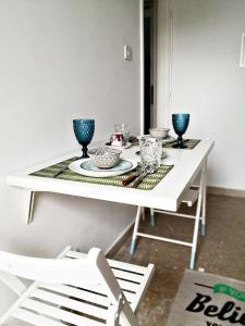 a white table with blue bowls and plates on it at Cozy Getaway in Nicosia in Yukarı Lakatamya