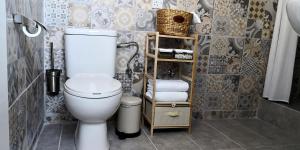 a bathroom with a toilet and a shelf with towels at Cozy Getaway in Nicosia in Yukarı Lakatamya