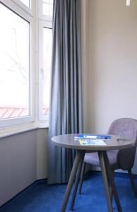 a table and two chairs in a room with a window at Hotel Wehrburg in Cuxhaven