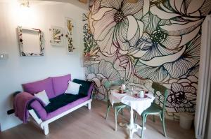 a living room with a purple couch and a table at La Casina di Cioccolata in Barberino di Val dʼElsa