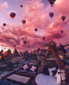 a group of hot air balloons flying over a city at The Owl Cave Hotel in Goreme