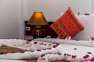 2 camas con almohadas rojas y blancas y flores. en Zama Resort Koh Phangan, en Haad Chao Phao