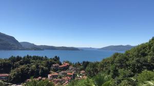 a house on a hill next to a body of water at Venegoni Maison De Charme in Ghiffa