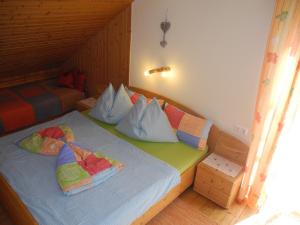 ein Schlafzimmer mit einem Bett mit Kissen darauf in der Unterkunft Entschleunigungshof Huberbauer in Kötschach