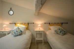 2 camas en una habitación con 2 lámparas en las mesas en Gîte Le Cocoon d'Isatis 2, en Montgiscard