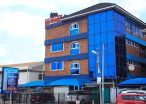 un edificio con ventanas azules y un coche aparcado delante en Ridge Over Suite, en Accra