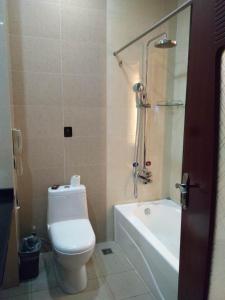 a bathroom with a toilet and a shower and a sink at Dunhuang Tianrun International Hotel in Dunhuang