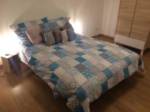 a bedroom with a bed with a blue and white quilt at Apartment Galerija in Tuzla