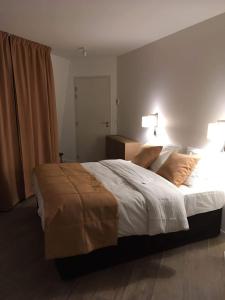 a bedroom with a large bed with two lamps at Hotel Ferney République in Paris