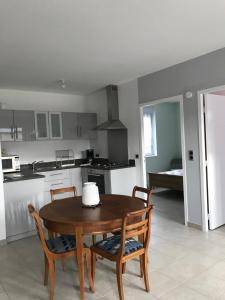 Thiergevilleにあるla grange aux hortensiasのキッチン(木製テーブル、椅子2脚、テーブル付)