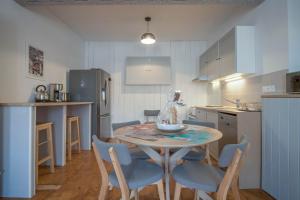 a kitchen with a table and chairs in a kitchen at Gîte Le Cocoon d'Isatis 2 in Montgiscard