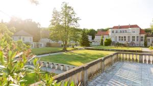 een groot huis met een tuin en een hek bij Landhaus am Jungfernsee in Potsdam