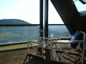 2 sillas en un balcón con vistas a la montaña en Haus Talblick Sasbachwalden, en Sasbachwalden