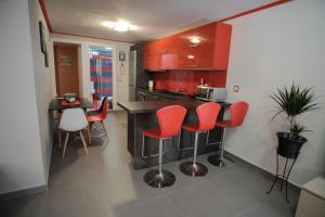 a kitchen with red cabinets and a table and chairs at casa al mare in Kavála