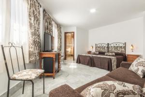 salon z dwoma łóżkami i telewizorem w obiekcie Hotel La Parrita w mieście Rota +24 zdjęcia