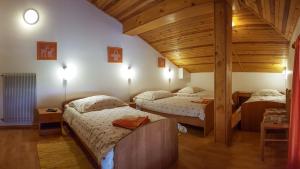 a bedroom with two beds and a wooden ceiling at Rooms with shared kitchen Zver, great for hikers in Hudajužna