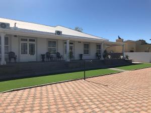a white house with a lawn in front of it at French Karoo Guesthouse in Beaufort West