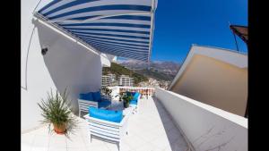 a balcony with blue and white chairs and a view at Apartments Villa Jovovic in Budva