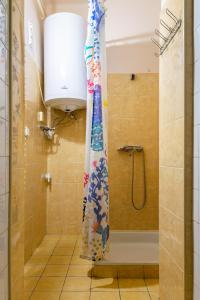 La salle de bains est pourvue d'une douche avec rideau de douche. dans l'établissement Lima Hostel Győr, à Győr