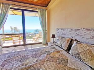 a bedroom with a large bed and a large window at Souda Bay Cottage in Plakias