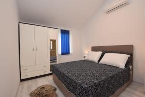 a bedroom with a large bed and a dresser at Seafront new apartments Zdrijac XI in Nin
