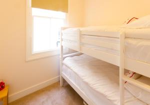 1 Schlafzimmer mit 2 Etagenbetten und einem Fenster in der Unterkunft Thorne Lodge in Eastbourne