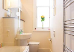 a bathroom with a toilet and a sink and a window at Thorne Lodge in Eastbourne