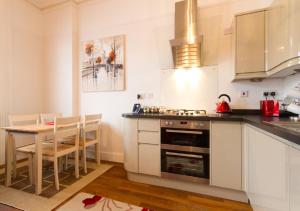 een keuken met een tafel en een fornuis top oven bij Thorne Lodge in Eastbourne