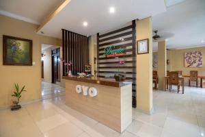 a restaurant with a counter in the middle of a lobby at Super OYO Capital O 612 Dante Guesthouse in Gianyar