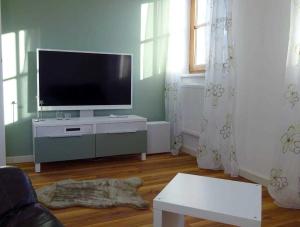 a living room with a flat screen tv on a cabinet at Ferienwohnungen _ WE DAHAMM in Memmelsdorf