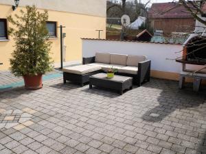 a patio with a couch and a table and a tree at Ferienwohnung Lang am Radweg in Heiligenstadt