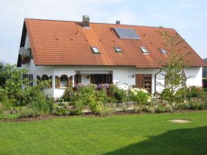 una casa blanca con techo naranja en Ferienwohnungen Haberberger, en Pottenstein