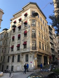 um edifício alto com pessoas à frente dele em GALATA M84 em Istambul