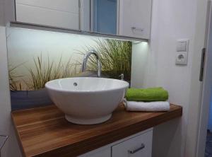 a bathroom with a white bowl sink on a wooden counter at Ferienwohnungen _ WE DAHAMM in Memmelsdorf