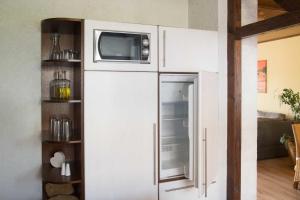 a white refrigerator with a microwave on top of it at Ferienwohnung Fraenkisches Paradies in Litzendorf