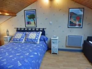 een slaapkamer met een bed met een blauw dekbed bij Les Aubretias in Fénay