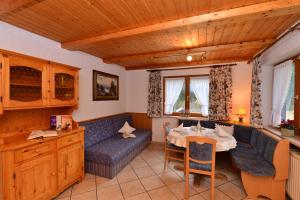 a living room with a table and a couch at Landhaus Almrausch in Mittelberg