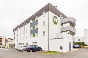 a building with a clock on the side of it at B&B HOTEL Tours Parc Expo St-Avertin in Saint-Avertin