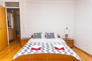 ein Schlafzimmer mit einem großen Bett mit roten Kissen in der Unterkunft Modern 2BDR apartment in the center- FREE PARKING in Sarajevo
