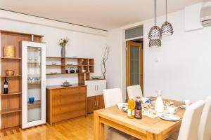 eine Küche und ein Esszimmer mit einem Holztisch und Stühlen in der Unterkunft Modern 2BDR apartment in the center- FREE PARKING in Sarajevo