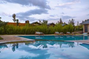 una piscina con 2 bancos en un patio en Anka Resort, en Naro Moru