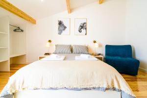 a bedroom with a bed and a blue chair at In2Lisbon - Kionga Suites in Lisbon