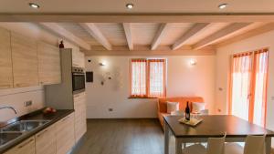 uma cozinha e sala de estar com mesa e cadeiras em Casa Guetti Terme di Comano em Comano Terme