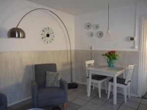 a dining room with a table and chairs and a clock at Buitengoed Het Achterdiep in Ter Apel