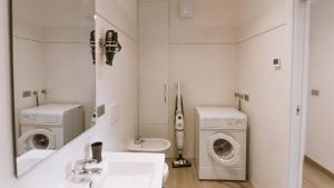 a white bathroom with a sink and a washing machine at Casa Guetti Terme di Comano in Comano Terme +16 photos