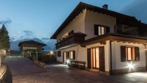 a white house with a bench in front of it at Casa Guetti Terme di Comano in Comano Terme