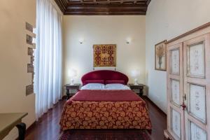 a bedroom with a bed with a red bedspread at Hotel Torre Guelfa Palazzo Acciaiuoli in Florence