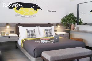 a bedroom with a bed with a laptop on it at Rooms Inc Semarang in Semarang