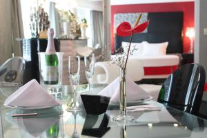 a glass table with a vase with a red flower on it at Surmeli Istanbul Hotel in Istanbul